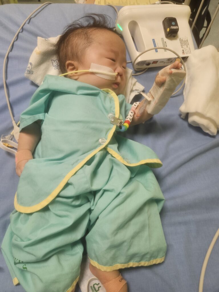 Baby Eva lying beside the medical devices and equipment to help with her breathing | Rare Disorders Society (Singapore) [RDSS]